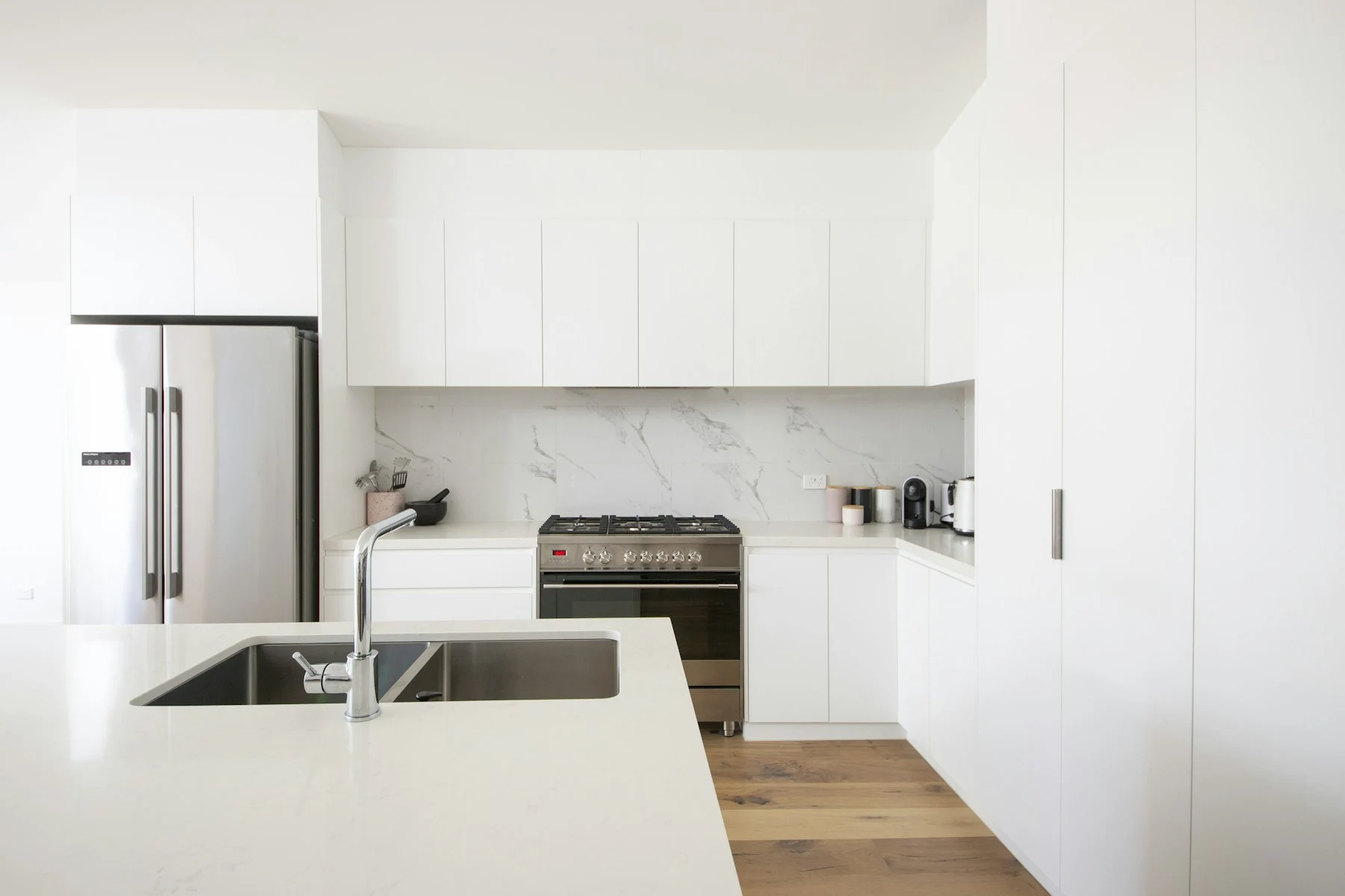 A bright, carefully arranged kitchen with clear counters and clean cabinetry